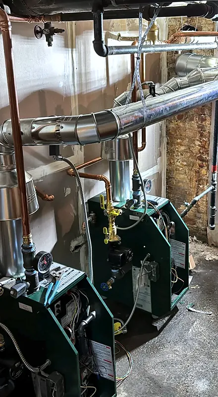 Two gas boilers with new venting, partway through an install