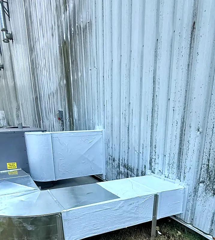 Ductwork running along the outside of a metal commercial building