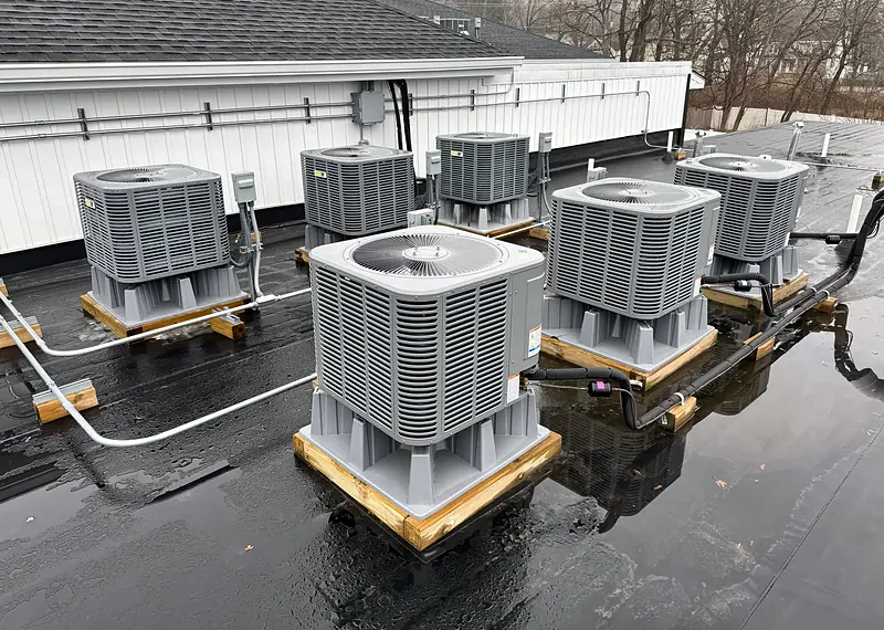 Row of condensing units on wood sleepers on a flat roof