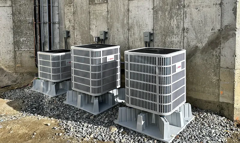 Three Bosch outdoor units on stands along a concrete foundation