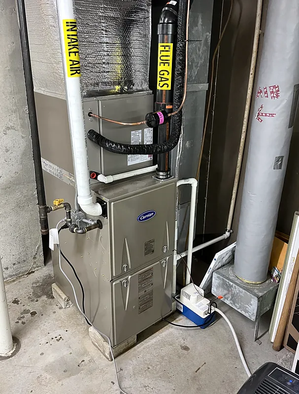 High-efficiency gas furnace with labeled intake air and flue gas pipes