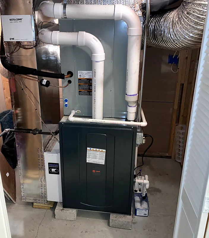 High-efficiency gas furnace with an evaporator coil, installed in a utility closet