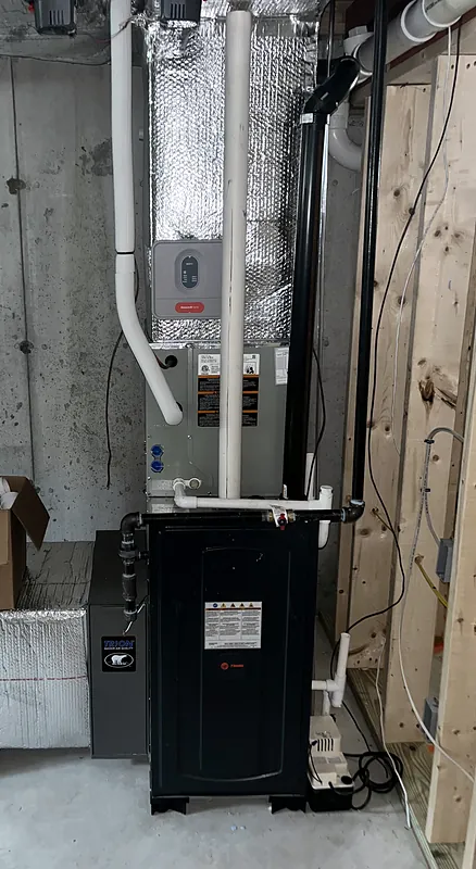 High-efficiency gas furnace with PVC venting and an evaporator coil in a basement