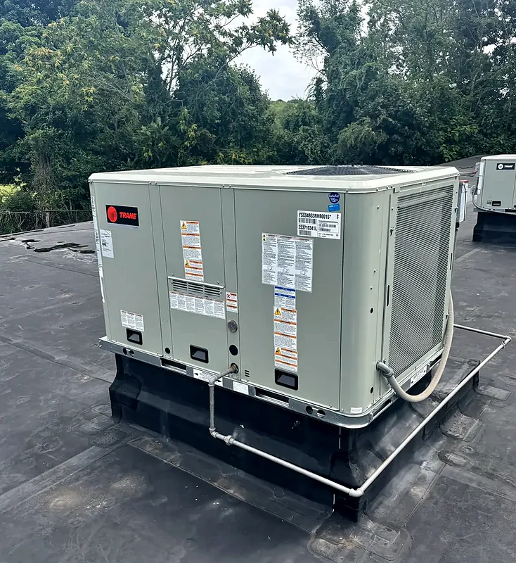 Trane packaged rooftop unit on a curb on a flat commercial roof