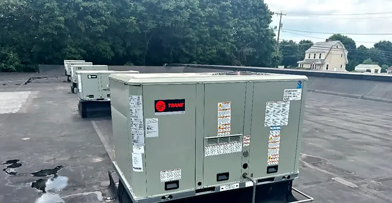 Trane packaged rooftop units in a row on a commercial roof