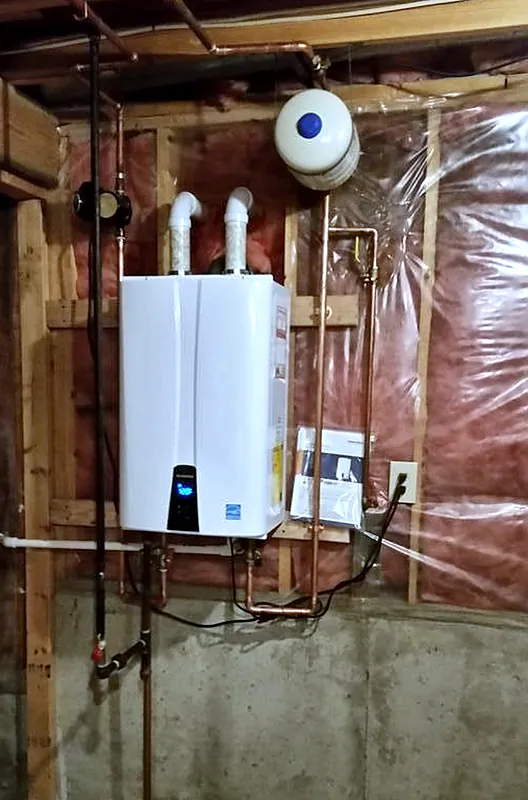 Wall-mounted gas tankless water heater with PVC venting and copper piping